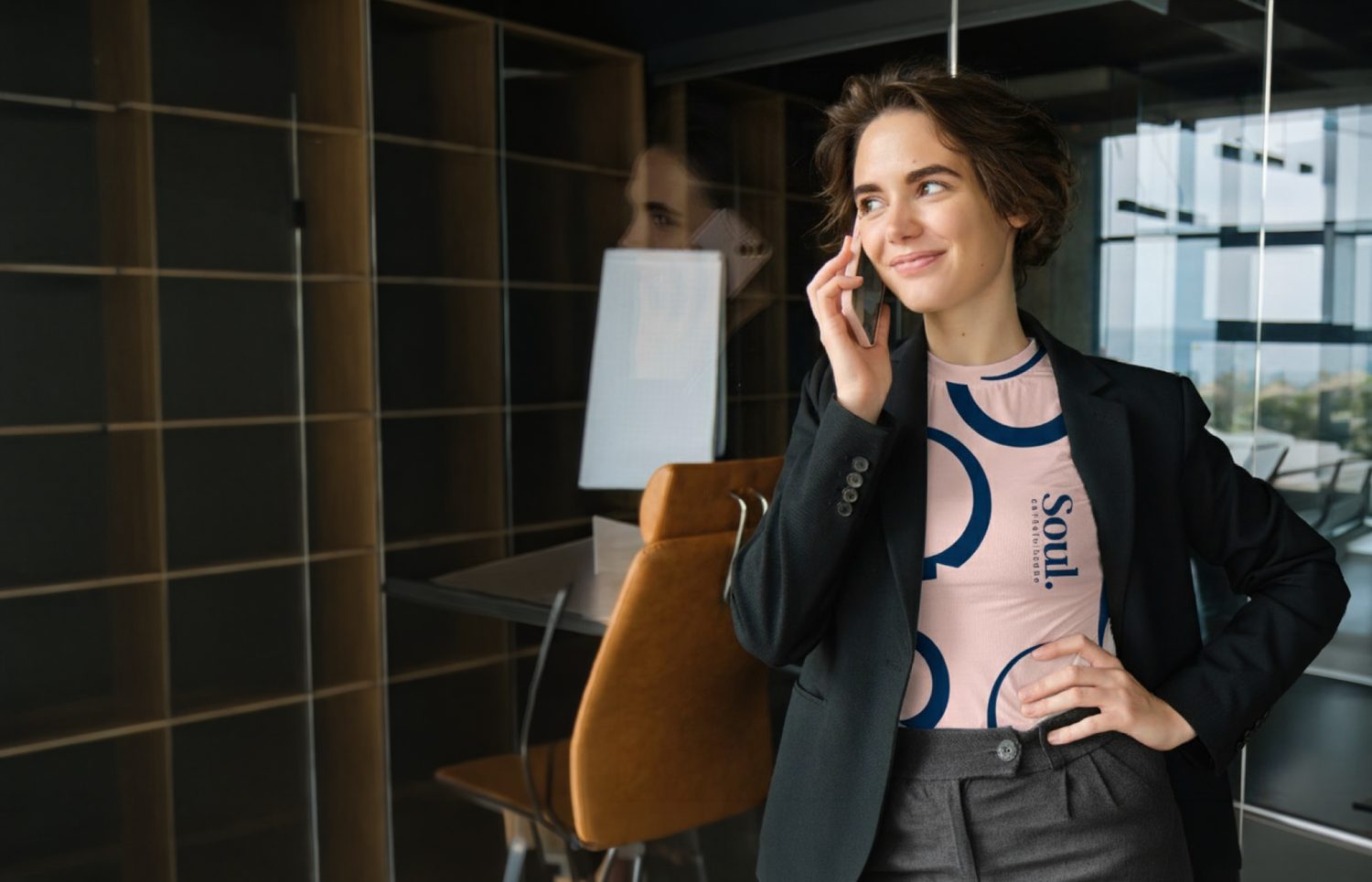 Profissional sorridente falando ao telefone em escritório, vestindo camiseta com a marca Soul
